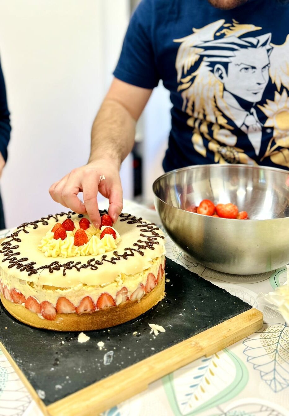 Photo d'un participant lors d'un atelier de cuisine sensorielle en train de déposer une fraise sur un fraisier.